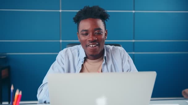 Succesvolle Afro-Amerikaanse man zet handen achter het hoofd voelt zich tevreden in het kantoor — Stockvideo