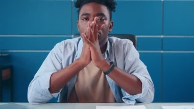 Ciddi bir Afro-Amerikan işadamı sert bir suratla kameraya bakıyor..