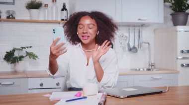 Çekici, neşeli, Afro-Amerikan kadın telefonla video görüşmesiyle konuşuyor..