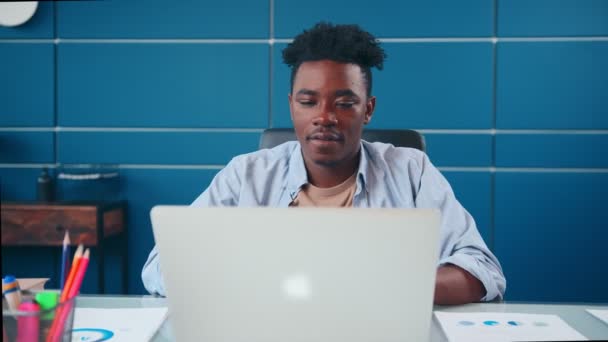 I tipi di uomo afroamericani di successo sul computer portatile poi si siede felicemente indietro sulla sedia. — Video Stock