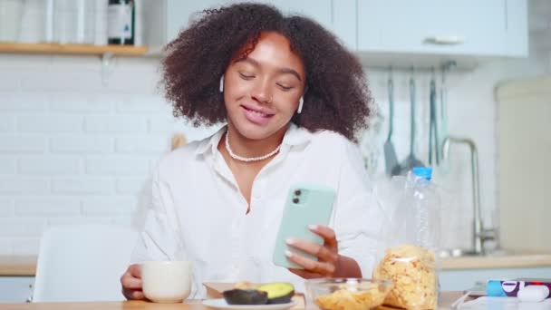 Pewna siebie młoda Afroamerykanka rozmawiająca wideo podczas śniadania. — Wideo stockowe