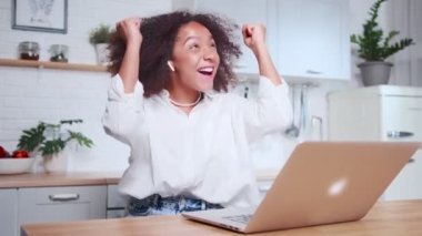 Coşkulu Afrikalı kadın sevinçten havalara uçuyor. İnternetten piyango kazanma sevinci.