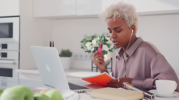 Joven mujer afroamericana leyendo el prospecto al interlocutor en el portátil. — Vídeo de stock