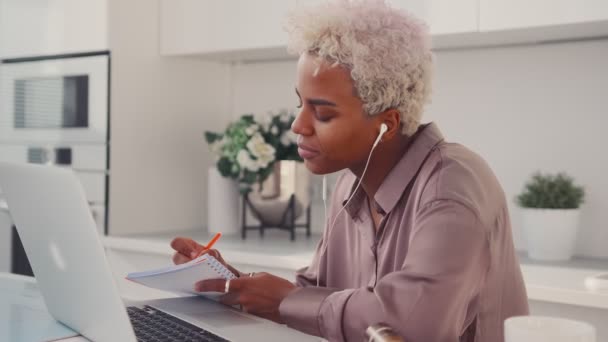 Afrikai amerikai női hallgató az online előadás során az asztalnál a konyhában — Stock videók