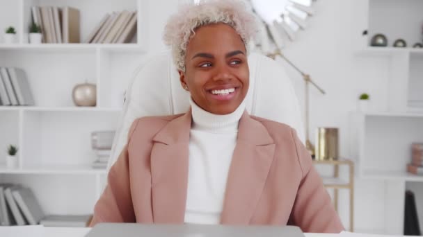 Sikeres afro-amerikai nő mosolyog és nevet, miközben ül a székben. — Stock videók