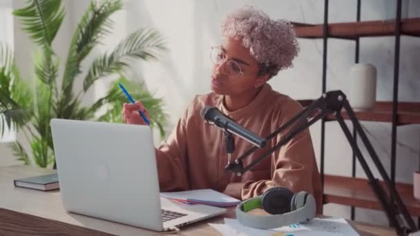Молодая афроамериканка, ведущая аудиоподкаст с ноутбуком студийный микрофон — стоковое видео