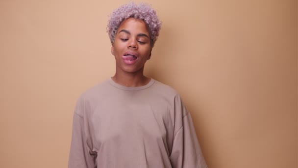 Vrolijke Afro-Amerikaanse vrouw rotzooien rond en het maken van grappige gezicht steken tong. — Stockvideo