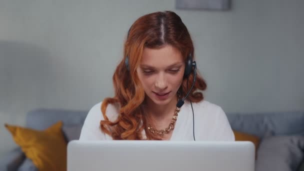 Mulher caucasiana com fone de ouvido falando e rindo olhando para laptop. — Vídeo de Stock