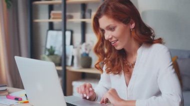 Aşırı neşeli Kafkasyalı kadın laptoptaki habere ya da mesaja seviniyor