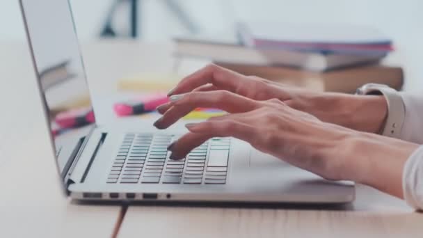 Perfil de cerca las manos de la mujer escribiendo en el ordenador portátil en la luz mesa de trabajo moderna — Vídeo de stock