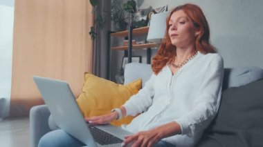 Laptop kullanan üzgün genç bir kadın bilgisayar sorunu yüzünden sinirleniyor.