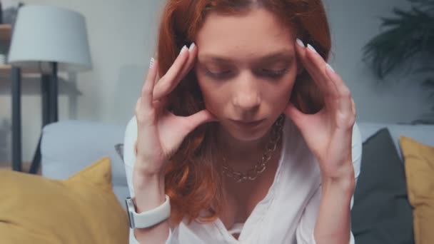 Primer plano de la mujer de pelo rojo joven molesto hacer frente a la migraña dolor de cabeza. — Vídeo de stock
