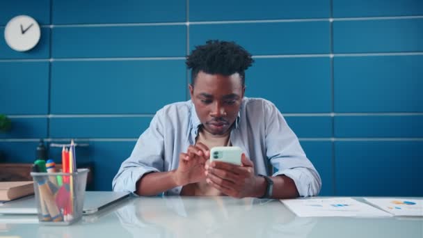 Joven hombre afroamericano llevado sobre el uso de teléfono y escribir mensajes en la aplicación. — Vídeos de Stock