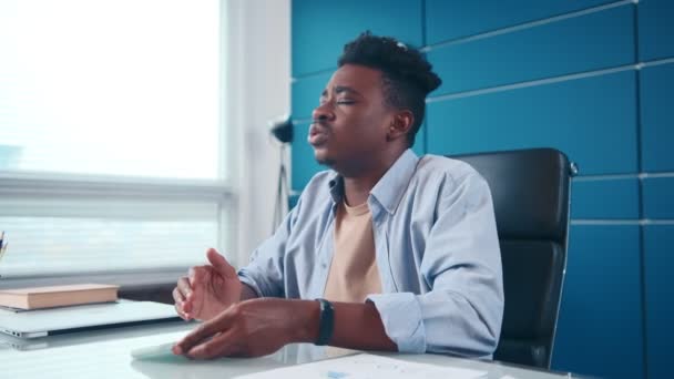 Frustrado afroamericano hombre consigue nervioso y flequillo manos en oficina mesa. — Vídeos de Stock