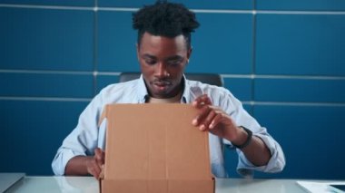 Hüsrana uğramış Afrikalı Amerikalı adam karton kutuyu açtı ve yanlış paket aldı..