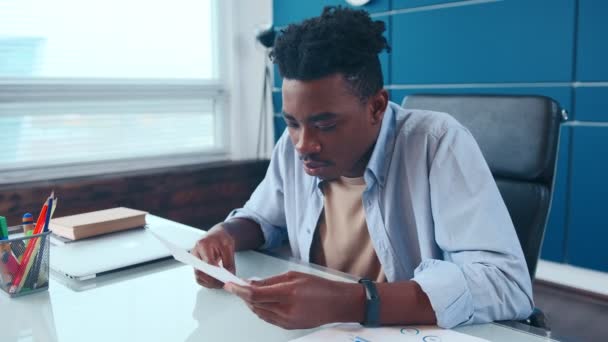 Возбужденный афроамериканец получает почту с выплатой роста зарплаты — стоковое видео