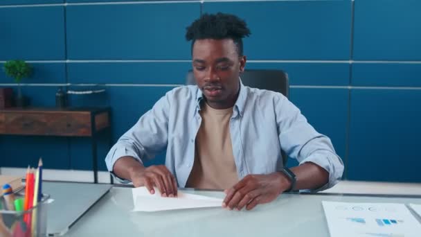 Africký Američan baví v kanceláři složený papír do letadla a spouštění. — Stock video