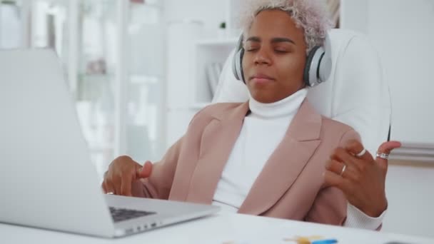 Framgångsrik afroamerikansk kvinna föreställer sig att spela gitarr sitter på kontoret. — Stockvideo