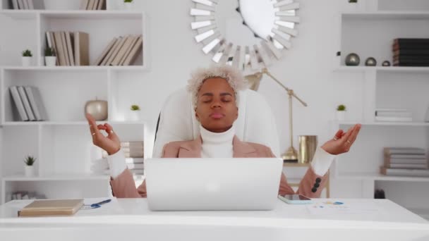 Junge erfolgreiche afroamerikanische Geschäftsfrau meditiert im Homeoffice. — Stockvideo