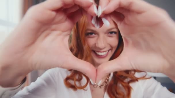 Donna rossa felice che fa gesto del cuore forma con le mani alla vigilia di San Valentino — Video Stock