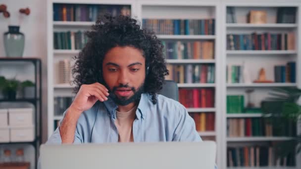 ヘッドセットを持つ若いアラビア人男性コンサルタントは、リモートで専門的なアドバイスを与える — ストック動画