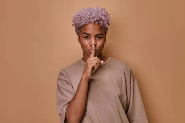 아프리카계 미국 여성, 입에 손가락을 대고 침묵의 몸짓을 한다 — 스톡 사진