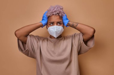 Yüz maskeli kızgın kadın başını tuttu ve salgın için endişelendi..