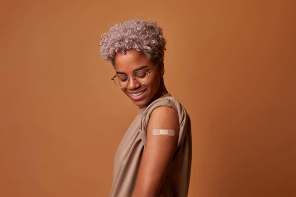 Femeia afro-americană cu tencuială pe mână se bucură de vaccinare omicron covid fotografii de stoc fără drepturi de autor