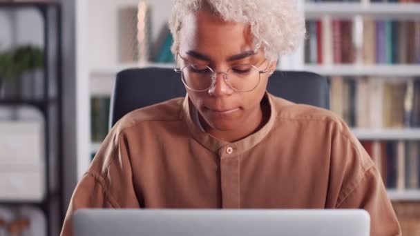 Νεαρή Αφροαμερικανή γυναίκα διστακτική δακτυλογράφηση και κοιτάζοντας φορητό υπολογιστή — Αρχείο Βίντεο