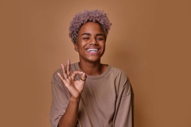 Neşeli genç Afrikalı Amerikalı kadın onaylama jesti yapıyor