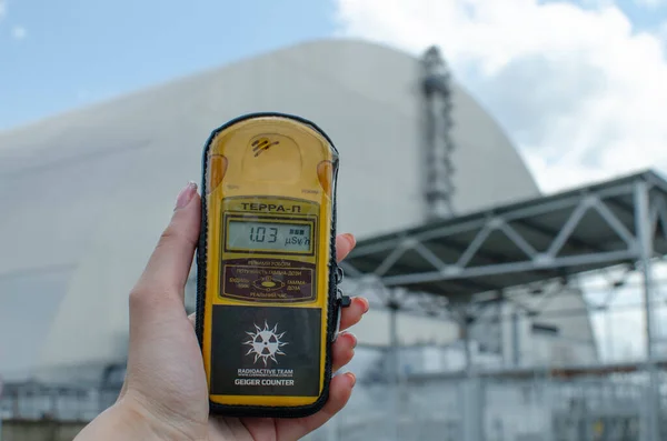 Felaketin yaşandığı Çernobil Nükleer Santrali 'nin arka planındaki radyasyon seviyesini ölçen bir el ölçümü. Pripyat, Ukrayna - 19 Haziran 2021