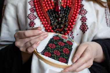 A girl embroiders a traditional Ukrainian vyshyvanka pattern