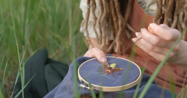 Close up of woman made hand embroidery of firefly