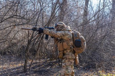Male modern soldier in the autumn forest 