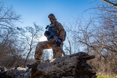 Male modern soldier in the autumn forest 
