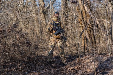 Male modern soldier in the autumn forest 