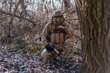 Male modern soldier in the autumn forest 