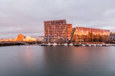 Reykjavik, İzlanda - 09 Temmuz 2020: Harpa konseri ve liman yazın gece yarısı güneşiyle sıcacık aydınlanıyor