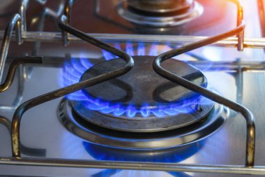 Mavi doğal gaz alevleri olan bir mutfaktaki gaz halkasını kapat. Doğal gaz fiyatı kavramı.