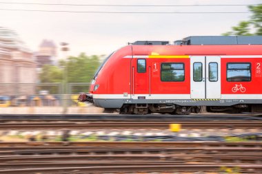 Kırmızı elektrikli yolcu treni istasyona giriyor. Bulanık hareket efekti.