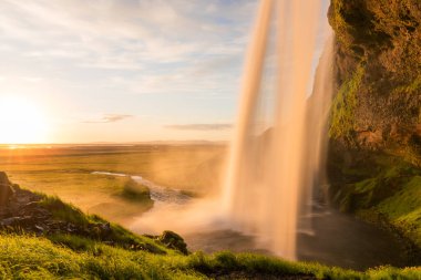 Gece yarısı güneş ışığında etkileyici bir şelale. Seljalandsfoss Şelalesi, İzlanda.
