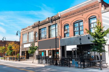 Güneşli bir sonbahar gününde şehir merkezinde bir cadde boyunca restoranları ve dükkanları olan geleneksel huş ağacı binaları. St., Catharines, On, Kanada.