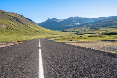 Açık bir yaz gününde İzlanda 'da boş, dolambaçlı dağ yolu