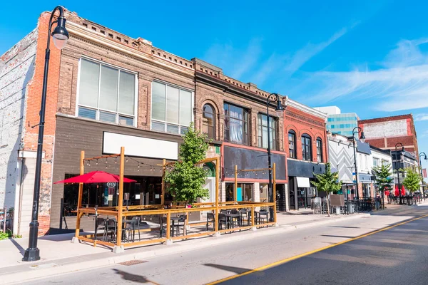 Geleneksel Amerikan mimarisi, açık bir sonbahar gününde şehir merkezindeki bir cadde boyunca zemin katta dükkanları ve restoranları olan bir yer. St. Catharines, On, Kanada.