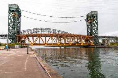 Limana giden bir kanal üzerinde dikey kaldırma köprüsü. Arka planda bir otoban viyadük görünüyor. Hamilton, On, Kanada.