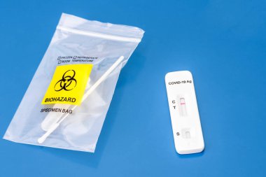 Mavi arka planda SARS CoV-2 hızlı antijen test kiti. Test şeridi negatif sonuç veriyor..