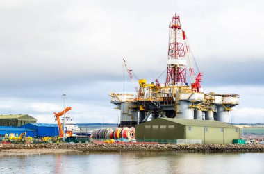 Bulutlu bir kış gününde bakım için kuru bir rıhtımda petrol platformu. Invergordon, İskoçya, İngiltere.