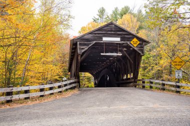 Eski ahşap bir şerit bulutlu bir sonbahar gününde köprüyle kaplıydı. New Hampshire, ABD.