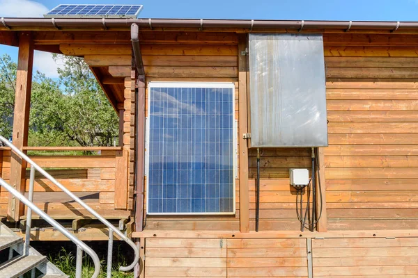 在阳光明媚的夏日 室外墙壁上的太阳能电池板和房顶上的木制小木屋 可再生能源概念 Hofn — 图库照片