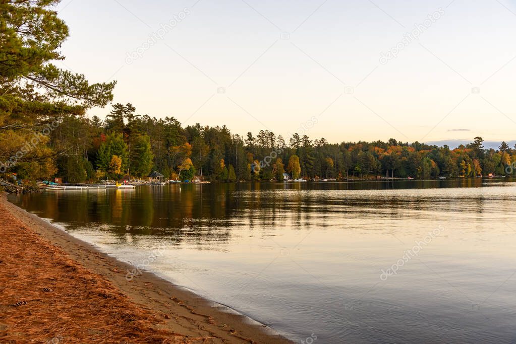 Wooden jetties along the wooded shores of lake at dusk in autumn. Tranquil scene. Dwight, ON, Canada.